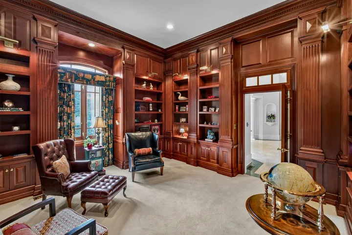 Wood-paneled study with built-in bookshelves and leather seating