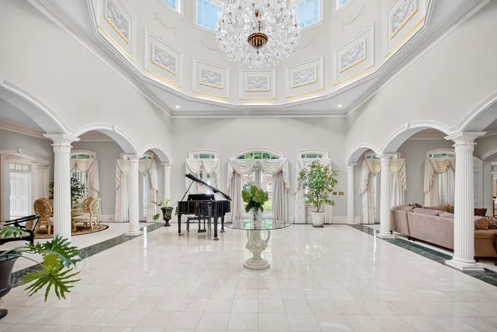 Central rotunda with columns, arched openings and a grand piano