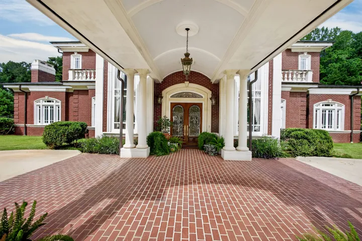 Covered brick-paved porte-cochère leading to the front doors