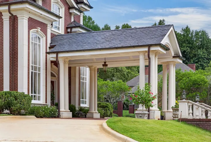 Columned porte-cochère beside the two-story entry windows